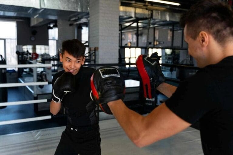 Teen students learning proper punching form in a structured beginner boxing class.