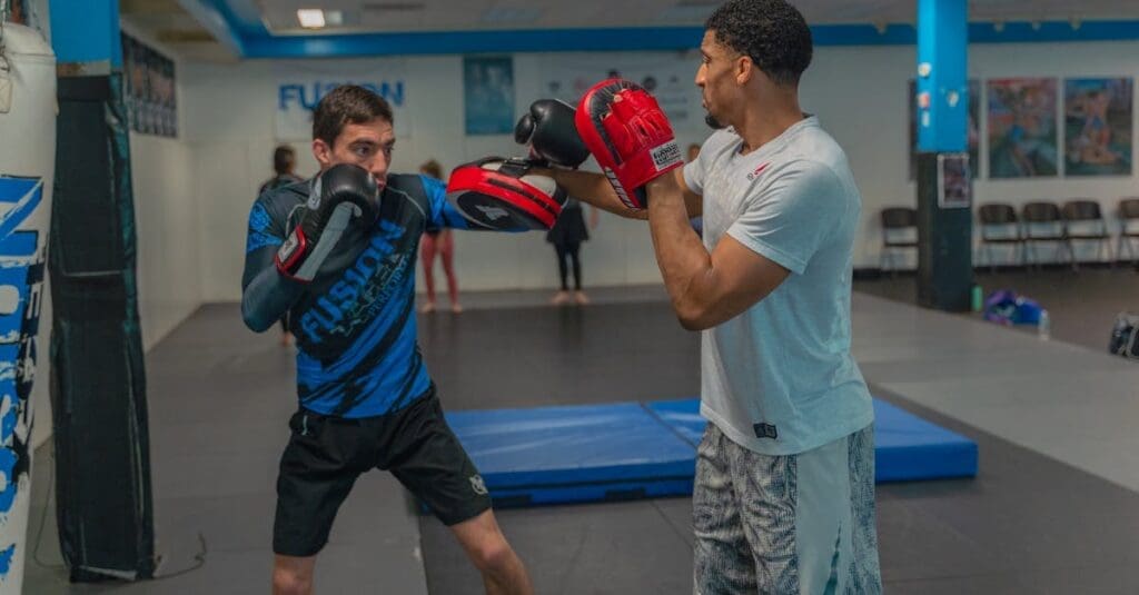 Coach holding focus mitts for martial arts fundamentals striking practice